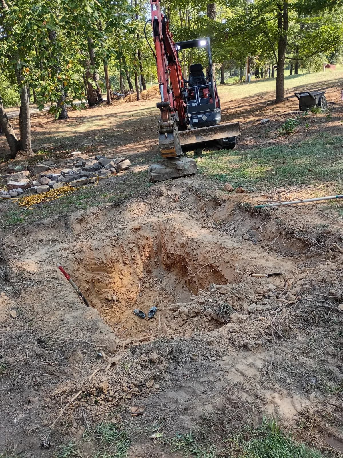 Deep excavation area being worked with a Red Dirt mini excavator